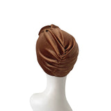 Brown turban on a white mannequin head against a white background