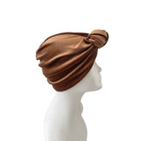 Brown turban on a mannequin head against a white background