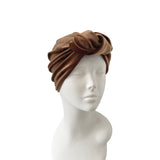 Brown turban on a mannequin head against a white background
