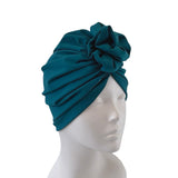 Teal headscarf on a mannequin head against a white background