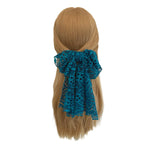 Blue lace hair clip on a mannequin head with blonde hair against a white background