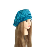 Mannequin head with long brown hair wearing a blue satin hair bonnet on a white background