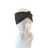 Black and brown patterned headband on a mannequin head against a white background