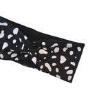 Black headband with white polka dot pattern on a white background