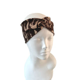 Brown patterned headband on a mannequin head against a white background