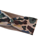 Camouflage-patterned fabric with a brown base on a white background