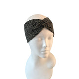 Black patterned headband on a mannequin head against a white background