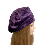 Mannequin head wearing a purple velvet turban on a white background