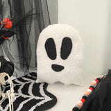 Ghost-shaped pillow on a Halloween-themed background with spider webs and skeleton.