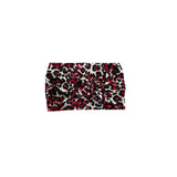 A leopard print headband featuring a pattern of red, black, and white spots, shown flat against a solid white background.