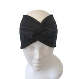 Black knitted headband on a mannequin head against a white background