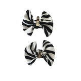 Two black and white striped bows with clips on a white background