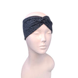 A black and gray leopard print twisted headband displayed on a light pink mannequin head against a plain white background.