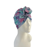 Colorful patterned headscarf on a mannequin head against a white background