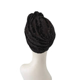 Black lace headscarf on a mannequin head against a white background