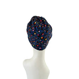 Navy blue headscarf with colorful patterns on a mannequin head against a white background