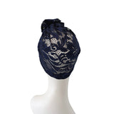 Navy lace headscarf on a mannequin head against a white background