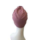 Pink turban on a mannequin head against a white background