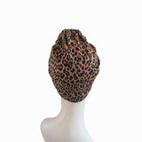 Leopard print headscarf on a mannequin head against a white background