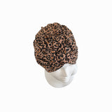 Leopard print turban on a white mannequin head against a white background