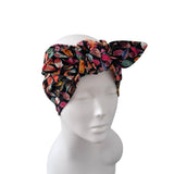 A multicolor floral print fabric headband styled on a white mannequin head against a plain white background.