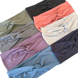 Collection of colorful knotted headbands in various shades on a white background