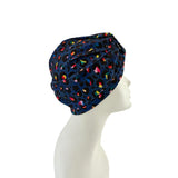 Navy blue headscarf with colorful patterns on a mannequin head against a white background