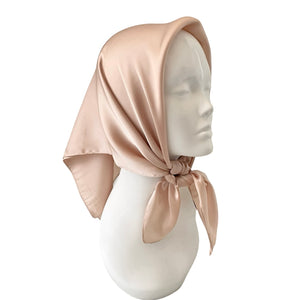Beige headscarf on a mannequin head against a white background