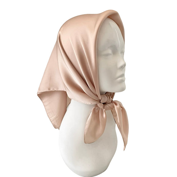Beige headscarf on a mannequin head against a white background