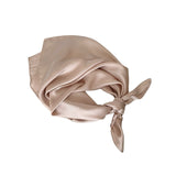 Beige silk scarf tied around the head on a white background