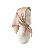 Beige headscarf on a mannequin head against a white background