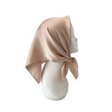 Beige headscarf on a mannequin head against a white background