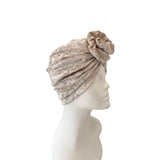 Beige headscarf with floral detail on a mannequin head against a white background