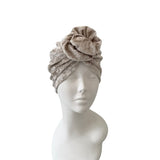 Gray headscarf with a flower on a mannequin head against a white background