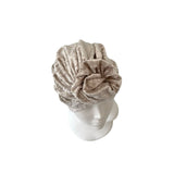 Beige towel turban on a mannequin head against a white background