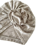 Beige velvet turban with a knot on a white background