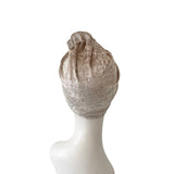 Beige headscarf on a mannequin head against a white background