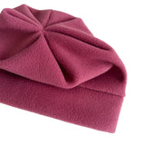 A folded dusty rose fleece blanket with a textured, soft surface, shown on a clean white background.