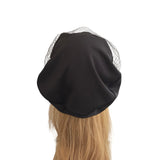 Black headscarf with a mesh veil on a mannequin head against a white background