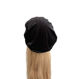 Black beret on a mannequin head with blonde hair against a white background