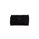 A black fabric headband with a large knotted bow detail at the center, presented flat against a solid white background.