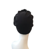Black turban on a mannequin head against a white background