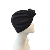 Black turban on a mannequin head against a white background