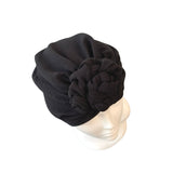 Black turban with a chain knot on a mannequin head against a white background