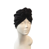 Black turban on a mannequin head against a white background
