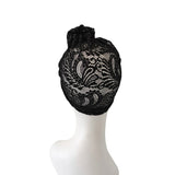 Black lace headpiece on a white mannequin head against a white background