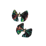 Two tropical leaf patterned bows with gold clips on a white background