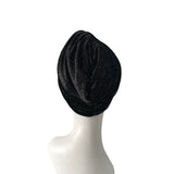Black knit headscarf on a mannequin head against a white background