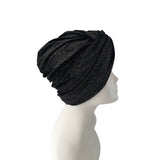 Black knit turban on a mannequin head against a white background