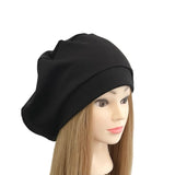 Black beanie on a mannequin head with long brown hair against a white background